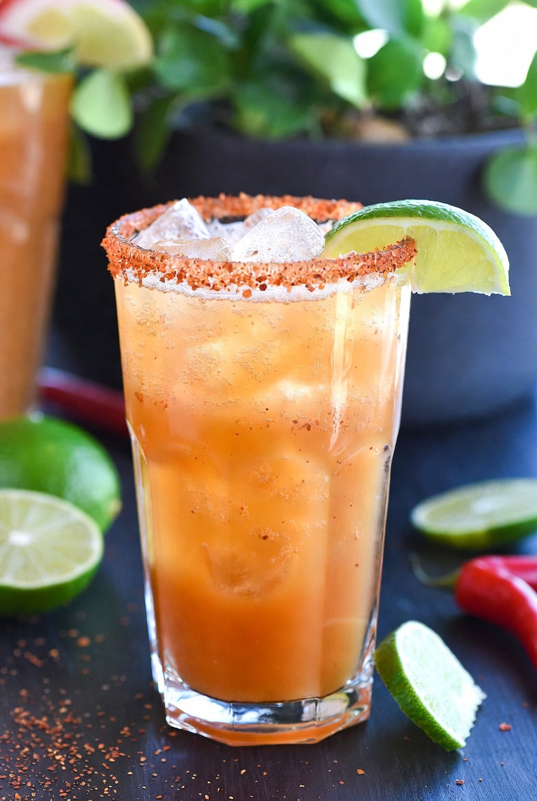 Classic Michelada in a chili-salt rimmed glass over ice with a lime wedge