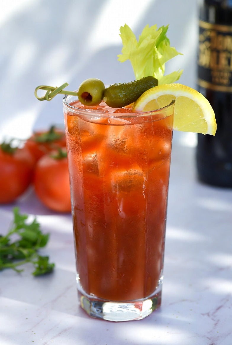 Red Snapper, a gin Bloody Mary, in a tall glass with celery, green olives, a baby pickle, and a lemon wedge